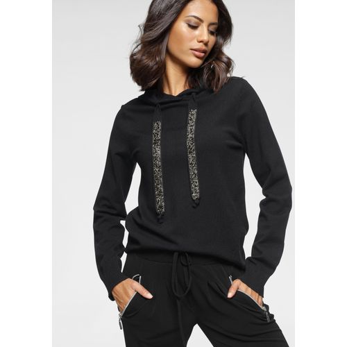 Laura Scott mit Kapuze und glitzernden Bändern